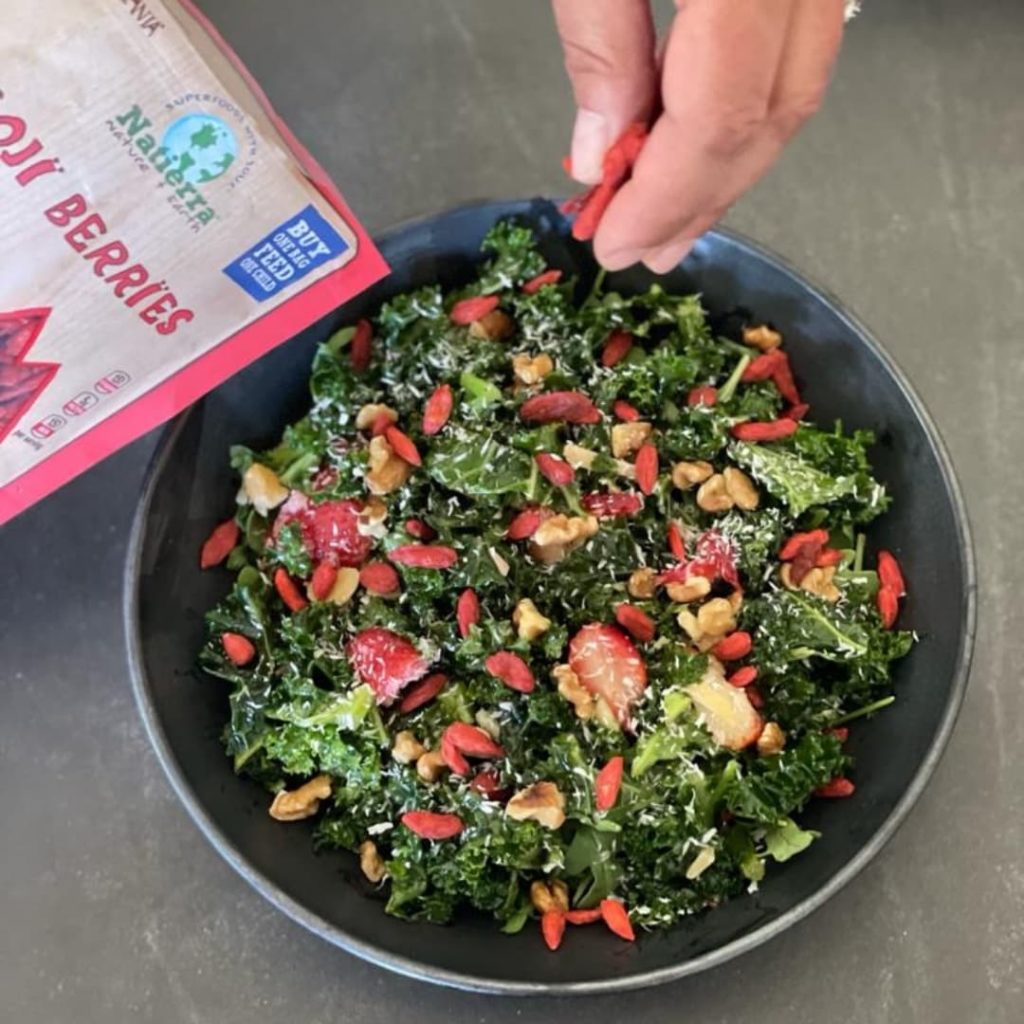 A delicious looking kale salad is garnished with some Natierra free dried berries.